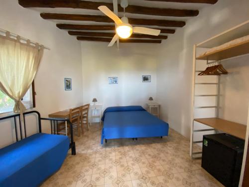 a bedroom with two beds and a ceiling fan at Pensione La Nassa in Stromboli