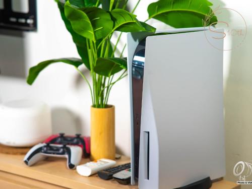 a white computer monitor sitting on a desk with a plant at Summer10th Pinesuites Scandi Minimalist Deluxe in Tagaytay