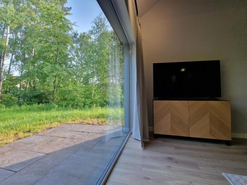a living room with a large window and a flat screen tv at Kalma Roztocze in Tereszpol Zaorenda