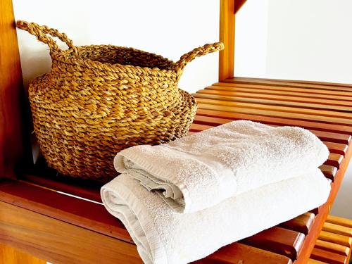 a stack of towels on a table with a basket at Kudos Boutique Hotel in Cabrera