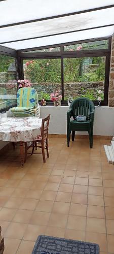 une pièce avec une table, des chaises et une fenêtre dans l'établissement Chez titine gîte du Bon Accueil, à Saint-Marcan
