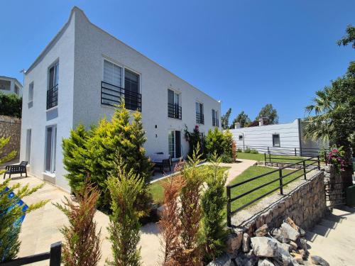 Una casa blanca con un muro de contención y plantas. en No 444, en Dalaman
