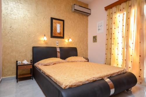 a bedroom with a bed with a black headboard at Orama Studios in Agia Anna Naxos
