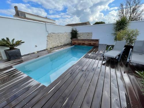 - une petite piscine sur une terrasse revêtue de parquet dans l'établissement Maison neuve t4 Toute équipée piscine chauffé, à Nieul-sur-Mer
