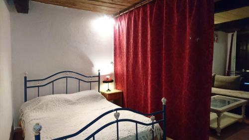 une chambre avec un lit et un rideau rouge dans l'établissement Studio Loft, à Belgentier