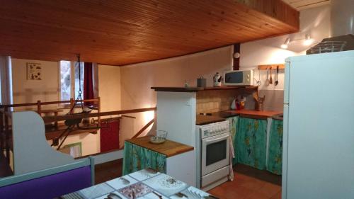 Il comprend une petite cuisine équipée d'une cuisinière et d'un réfrigérateur. dans l'établissement Studio Loft, à Belgentier