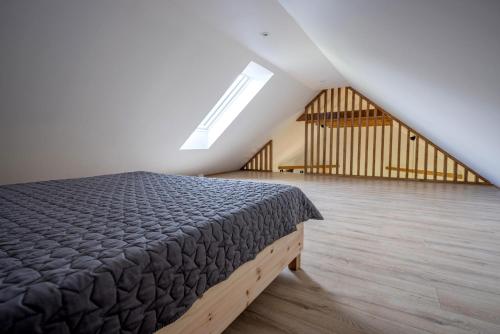a bedroom with a bed and a wooden floor at Wilcza Stodoła in Wilcze