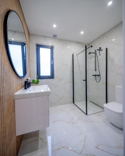 a bathroom with a shower and a sink and a mirror at Wilcza Stodoła in Wilcze