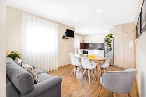 a living room with a couch and a table and chairs at Pontes Guest House in Arcozelo