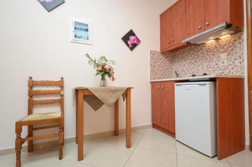 a kitchen with a table and a white refrigerator at Orama Studios in Agia Anna Naxos