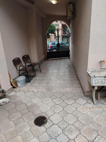 a hallway with a gate with chairs and a floor at Prenoćiste Živković in Pirot