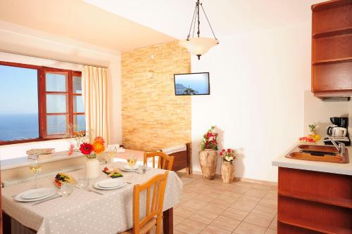a kitchen and dining room with a table and chairs at Stefanos Village Hotel in Plakias