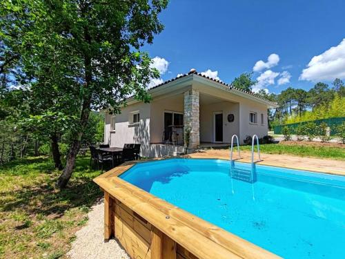 une maison avec une piscine devant une maison dans l'établissement Logement entier, à Gagnières