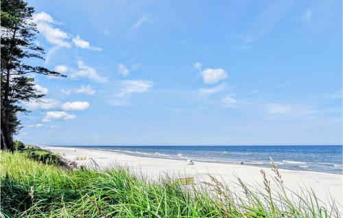 a beach with people walking on the sand and the ocean at Nice Apartment In Kopalino With Wifi in Kopalino
