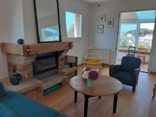 a living room with a fireplace and a table at Bevan Kaer in Ploubazlanec