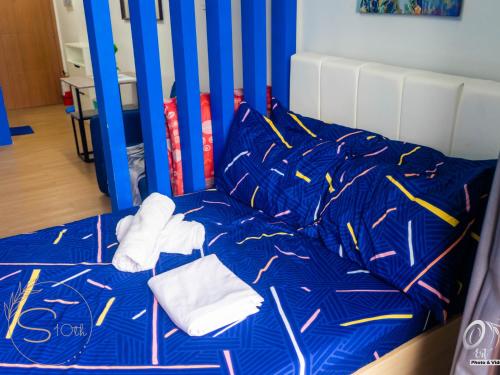 a bed with blue sheets and white towels on it at Summer10th Pinesuites Scandi Minimalist Deluxe in Tagaytay