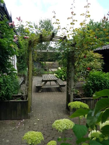a garden with a picnic table and a bench at B&B Land of Tir Nan Og in Lommel