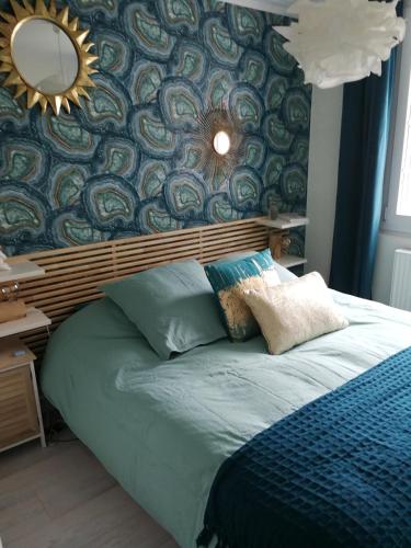 une chambre avec un grand lit avec un miroir au mur dans l'établissement Maison de pêcheur à 150 m de la mer avec jacuzzi, à Ouistreham