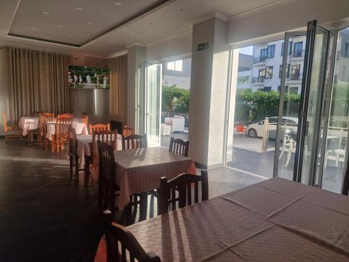 un restaurant avec des tables et des chaises et une vue sur une rue dans l'établissement Villa Premium, à Durrës