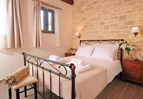 a bedroom with a bed and a brick wall at Stefanos Village Hotel in Plakias