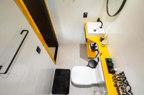 a bathroom with a white toilet and a sink at Casa Natu Ilhabela Portinho in Ilhabela