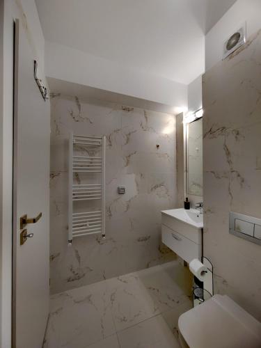 a white bathroom with a sink and a toilet at Studio President 52 in Craiova
