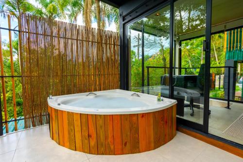 a large wooden tub in a room with windows at Casa Natu Ilhabela Portinho in Ilhabela