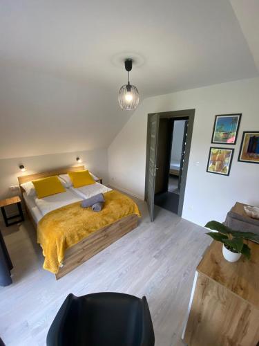 a bedroom with a large bed with a yellow blanket at Antracytowy Zakątek in Łeba