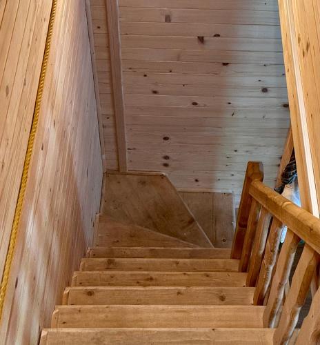 a staircase in a cabin with wooden walls and ceilings at Ustronne Chatki - Ostoja nad Potokiem in Ustroń