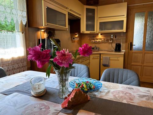 a vase of pink flowers sitting on a table at Ustronne Chatki - Ostoja nad Potokiem in Ustroń