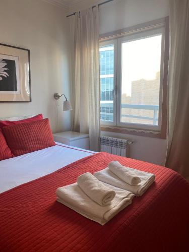 a bedroom with two towels on a bed with a window at Lisbon NH HomeVipNobel - Luxurious apartment in Lisbon