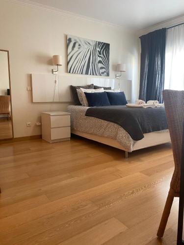 a bedroom with a large bed and a wooden floor at Lisbon NH HomeVipNobel - Luxurious apartment in Lisbon