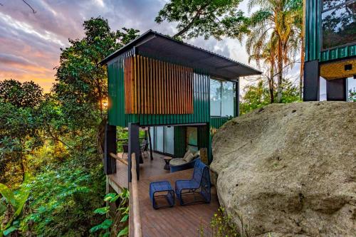 a house on a hill with a large rock at Casa Natu Ilhabela Portinho in Ilhabela
