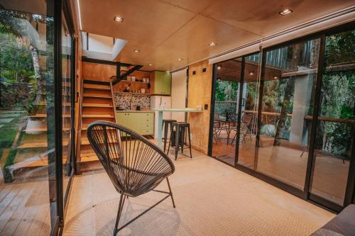 a room with a staircase and a chair in a house at Casa Natu Ilhabela Portinho in Ilhabela