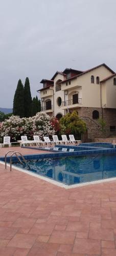 a swimming pool with lounge chairs and a building at Villa Anna in Leptokarya