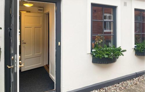 an open door of a house with two potted plants at 2 Bedroom Nice Home In Ystad in Ystad