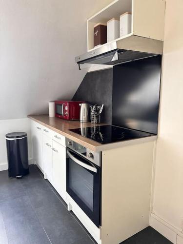a kitchen with a stove top oven in a kitchen at La Loge et La Pause Compiègnoise in Compiègne