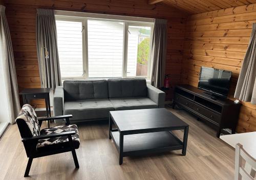 a living room with a couch and a tv at Chaletparc Krabbenkreek Zeeland - Chalet 96 in Sint Annaland