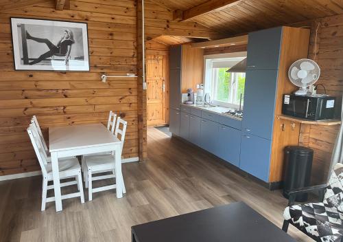 a kitchen with a table and chairs in a cabin at Chaletparc Krabbenkreek Zeeland - Chalet 96 in Sint Annaland