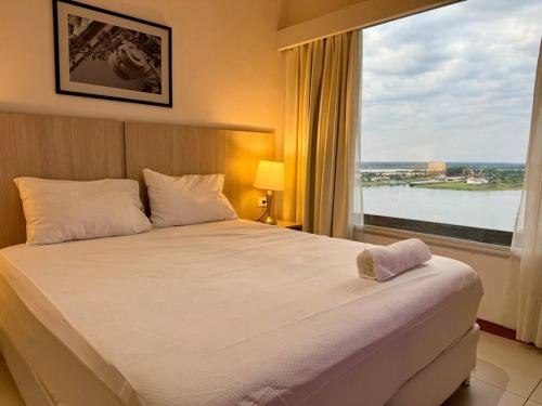 a bedroom with a large bed with a large window at Vista al Río Paraguay, Costanera Asu in Asuncion