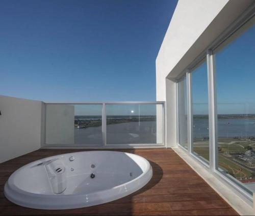 a bath tub in a room with a large window at Vista al Río Paraguay, Costanera Asu in Asuncion