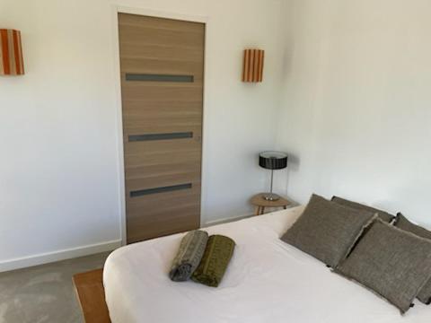 - un lit blanc avec 2 oreillers dans l'établissement un petit coin de paradis entre mer et terre, à La Cadière-dʼAzur