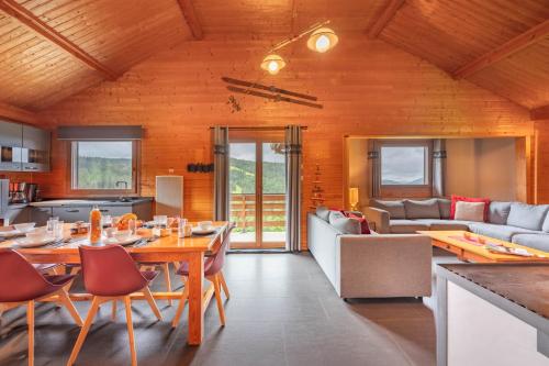 une salle à manger et un salon avec une table et des chaises dans l'établissement Chalet Dyna, luxe, calme et sérénité, à Gérardmer