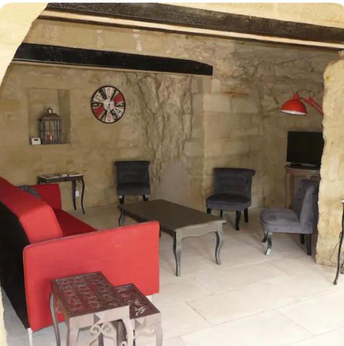 - un salon avec un canapé, des chaises et un réveil dans l'établissement Troglo Saumurois, à Chacé