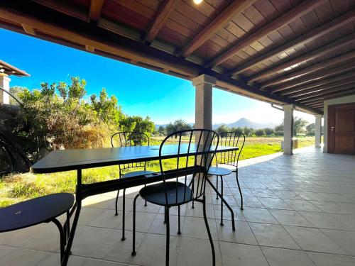 Una mesa y sillas en un patio con vista. en Cronta Apartments, en Bari Sardo