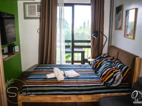 a bedroom with a bed with pillows and a window at Summer10th Pinesuites Scandi Minimalist Deluxe in Tagaytay