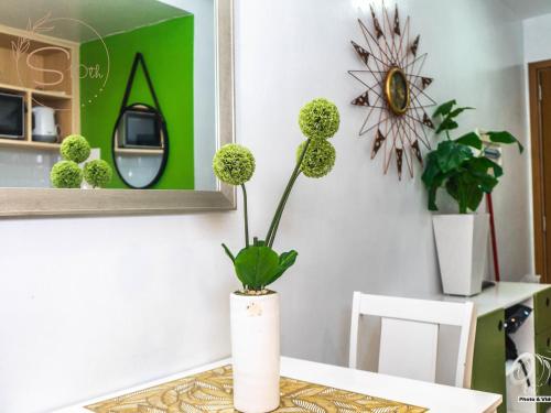 a table with a vase with a plant on it at Summer10th Pinesuites Scandi Minimalist Deluxe in Tagaytay