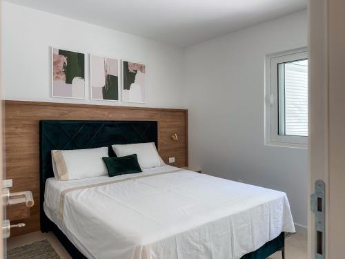 a bedroom with a bed with white sheets and a window at ChillOut apartment in Kotor Bay in Kotor