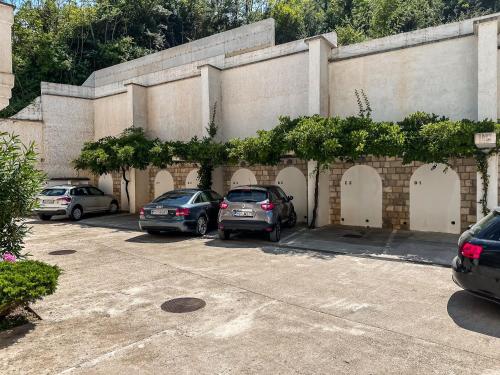 two cars parked in a parking lot in front of a building at ChillOut apartment in Kotor Bay in Kotor