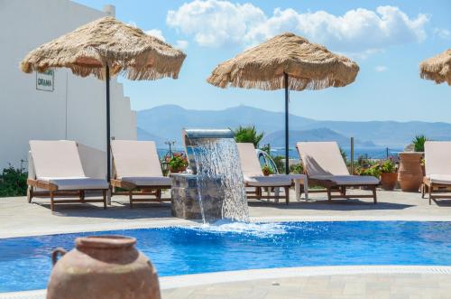una piscina con sillas, sombrillas y una fuente en Orama Studios, en Agia Anna de Naxos
